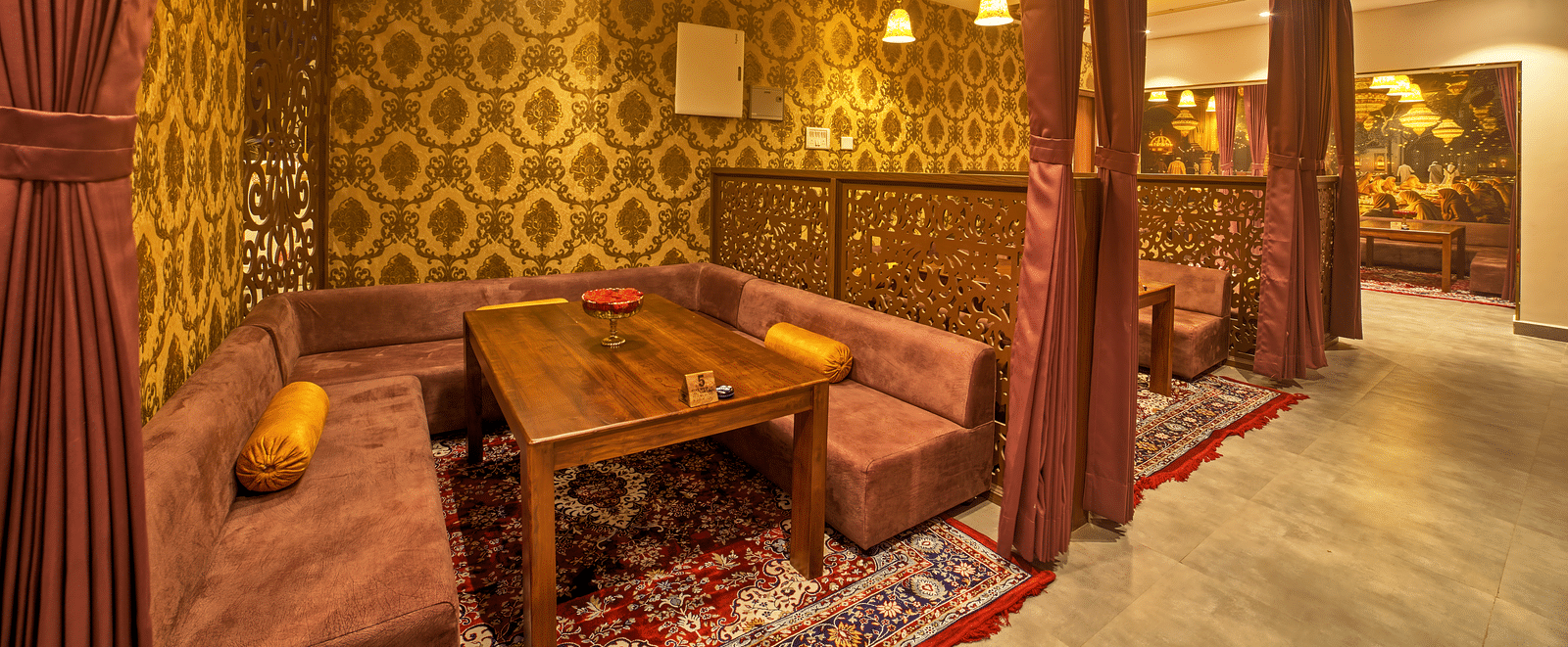Cosy dining with ornate wooden decor and warm lighting at Ilara Hotels & Spa, OMR, Chennai
