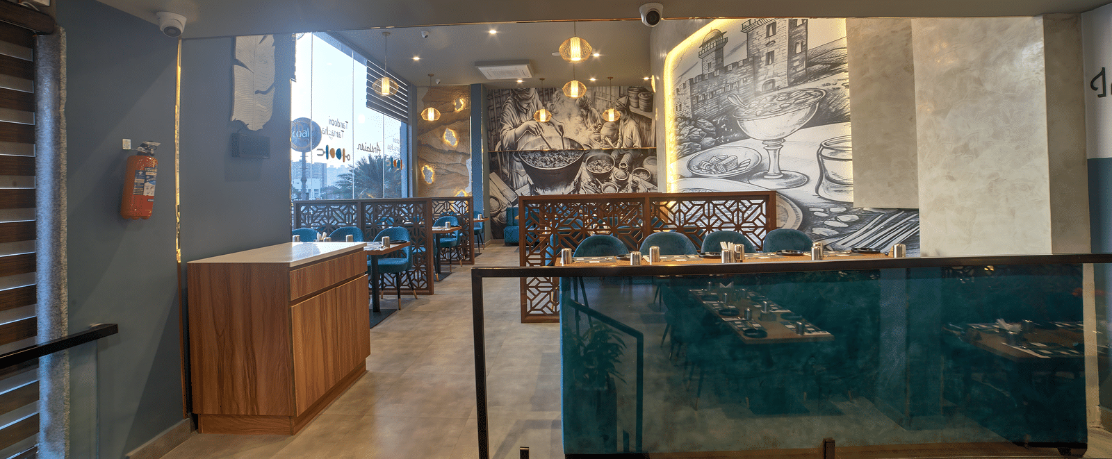 Artistic dining booths with blue seating and warm lighting at Ilara Hotels & Spa, OMR, Chennai