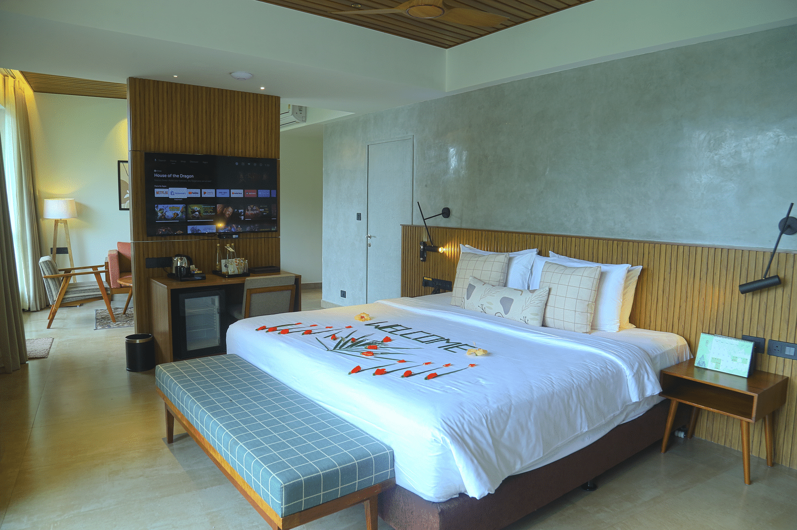 An image of the pent house room with a king size bed, couch, bed side table, and flat screen TV - Great Trails Yercaud by GRT Hotels