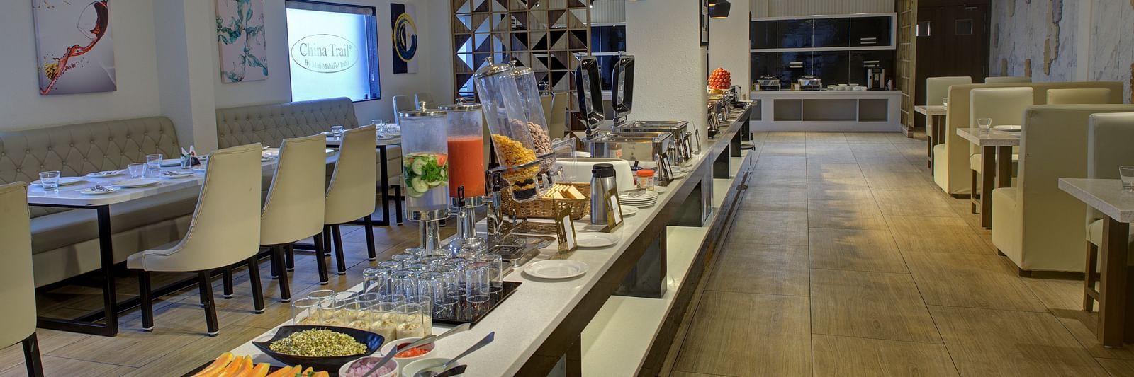 Full view shot of the buffet counter at the Moti Mahal Restaurant at Ilara Hotels & Spa, Tada with ambient lighting hanging from the ceiling above it.