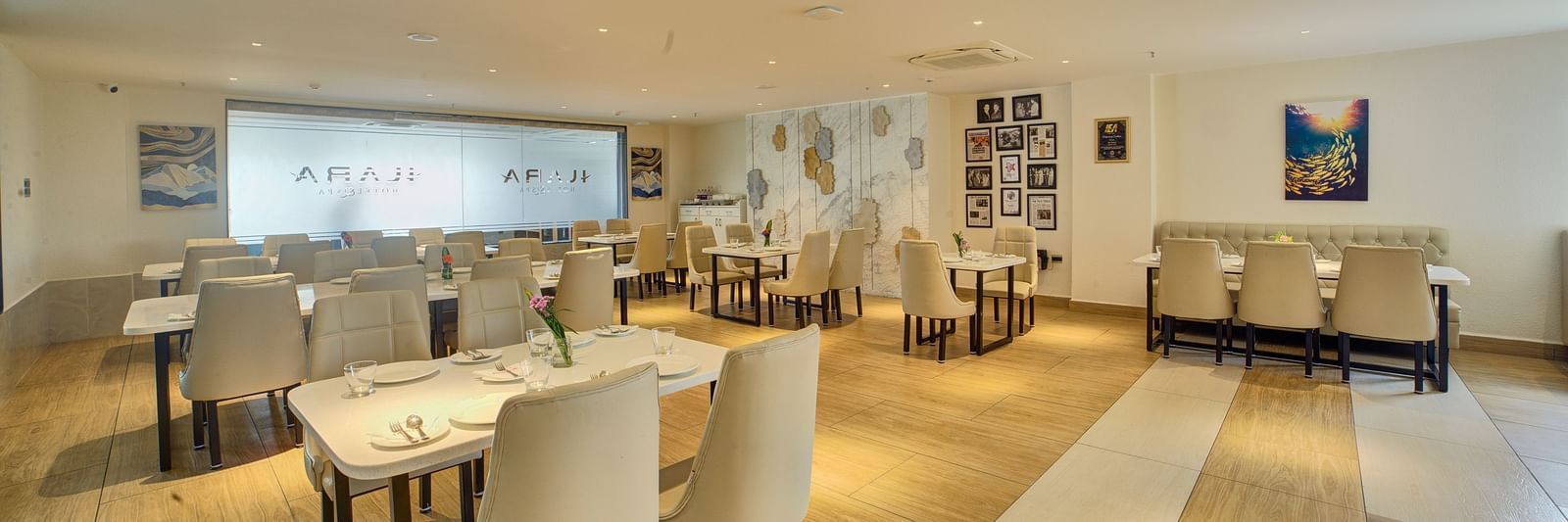 Back view of the Moti Mahal Restaurant with neatly arranged chairs and dining tables at Ilara Hotels & Spa, Tada.
