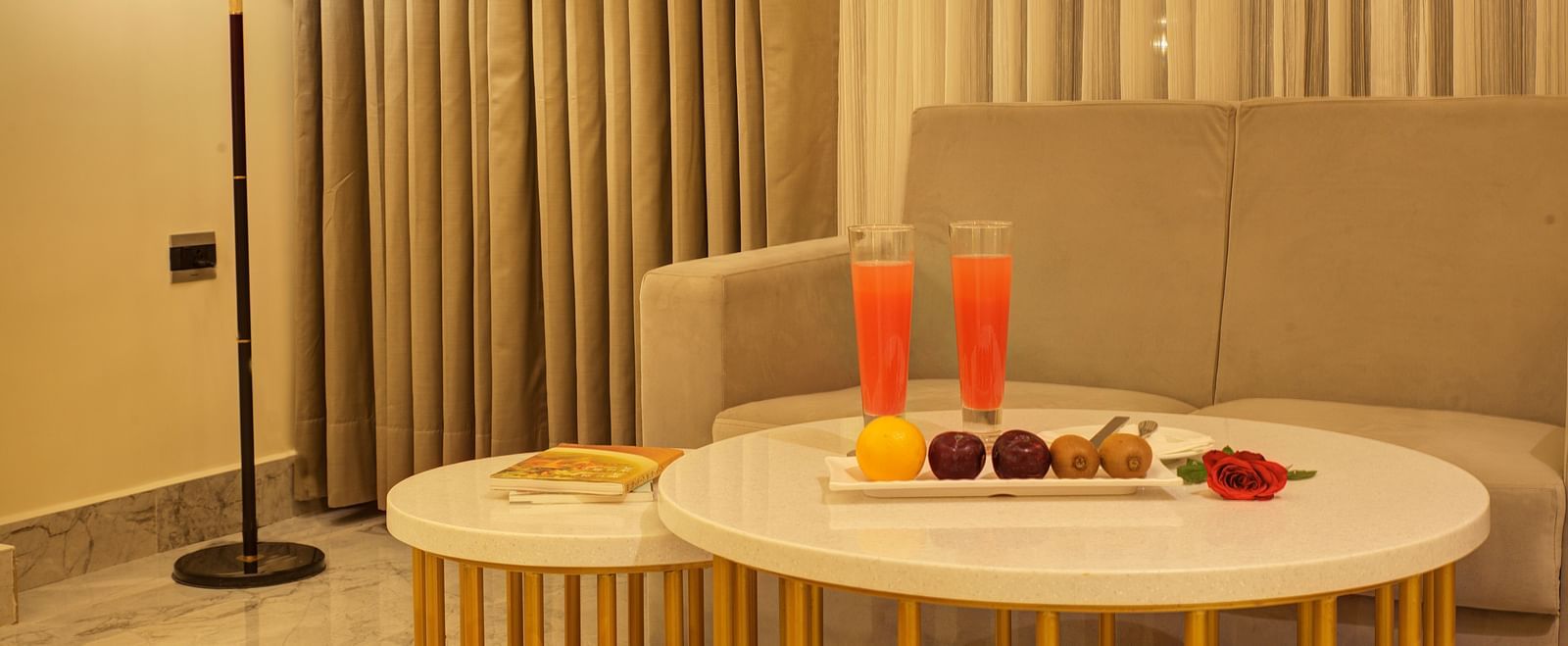 Close up shot of the coffee table with two tall glasses of fresh watermelon juice along with side dishes in the Junior Suite at Ilara Hotels & Spa, Tada.