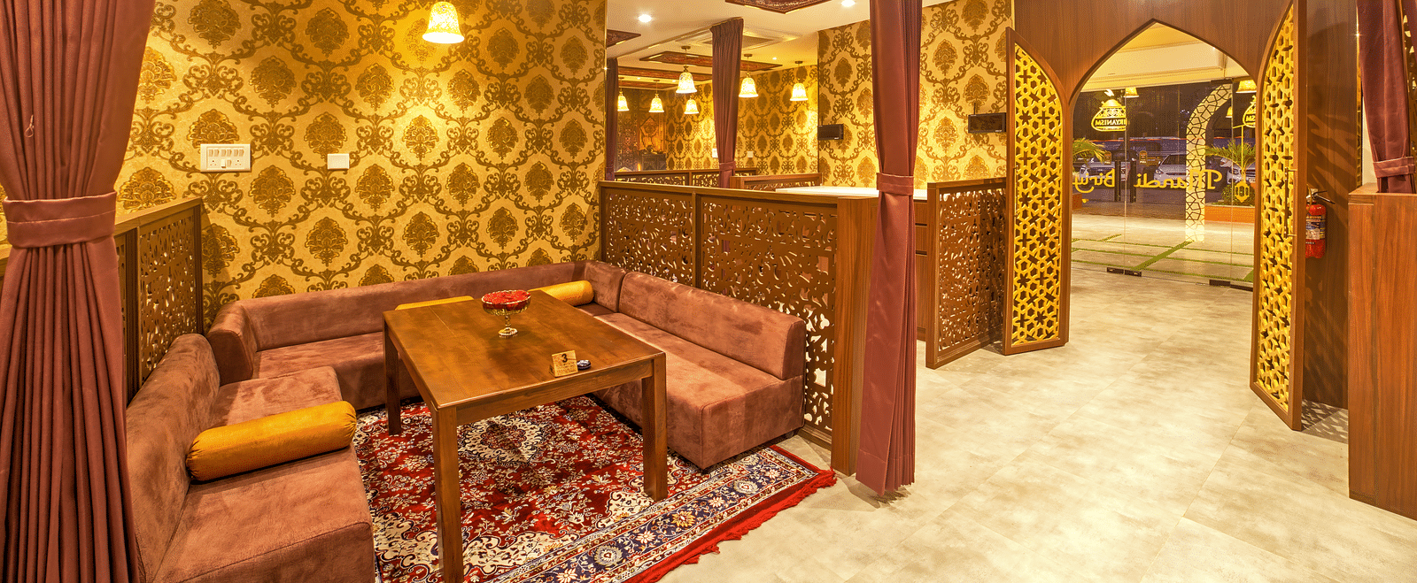 Cosy dining with ornate wooden decor and warm lighting at Ilara Hotels & Spa, OMR, Chennai
