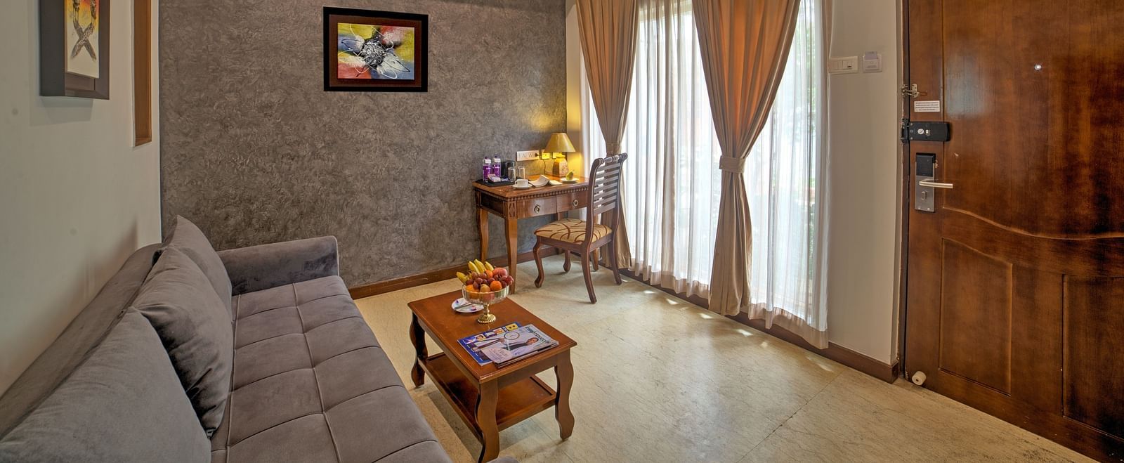 Contemporary suite with wooden door, sitting space, and soft lighting at Ilara Hotels & Spa, OMR, Chennai