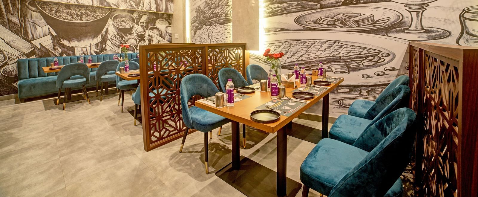 Artistic booth dining with illuminated mural and modern decor at Ilara Hotels & Spa, OMR, Chennai