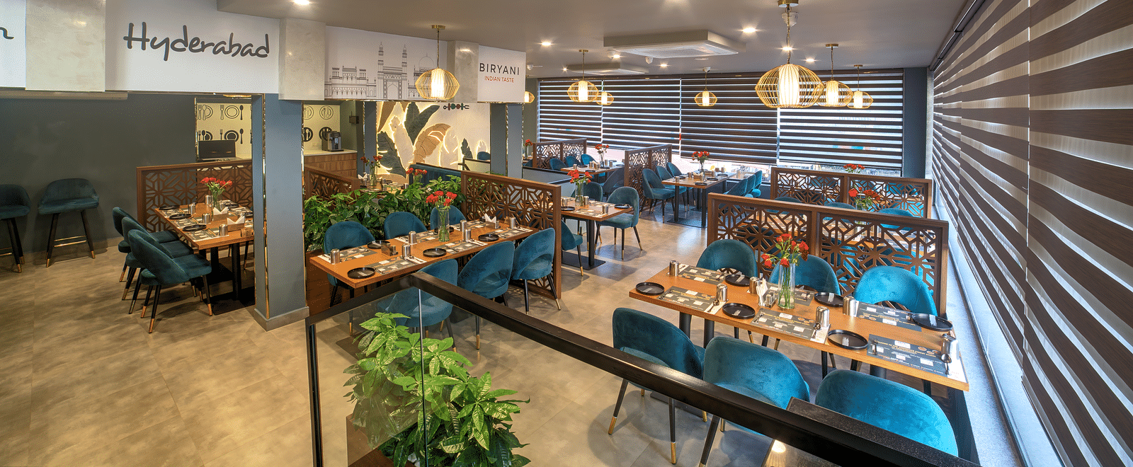 Modern dining area with teal chairs and ambient lighting at Ilara Hotels & Spa, OMR, Chennai