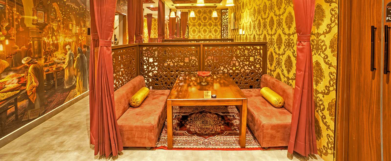 Royal-style booth with ethnic decor and mural artwork at Ilara Hotels & Spa, OMR, Chennai
