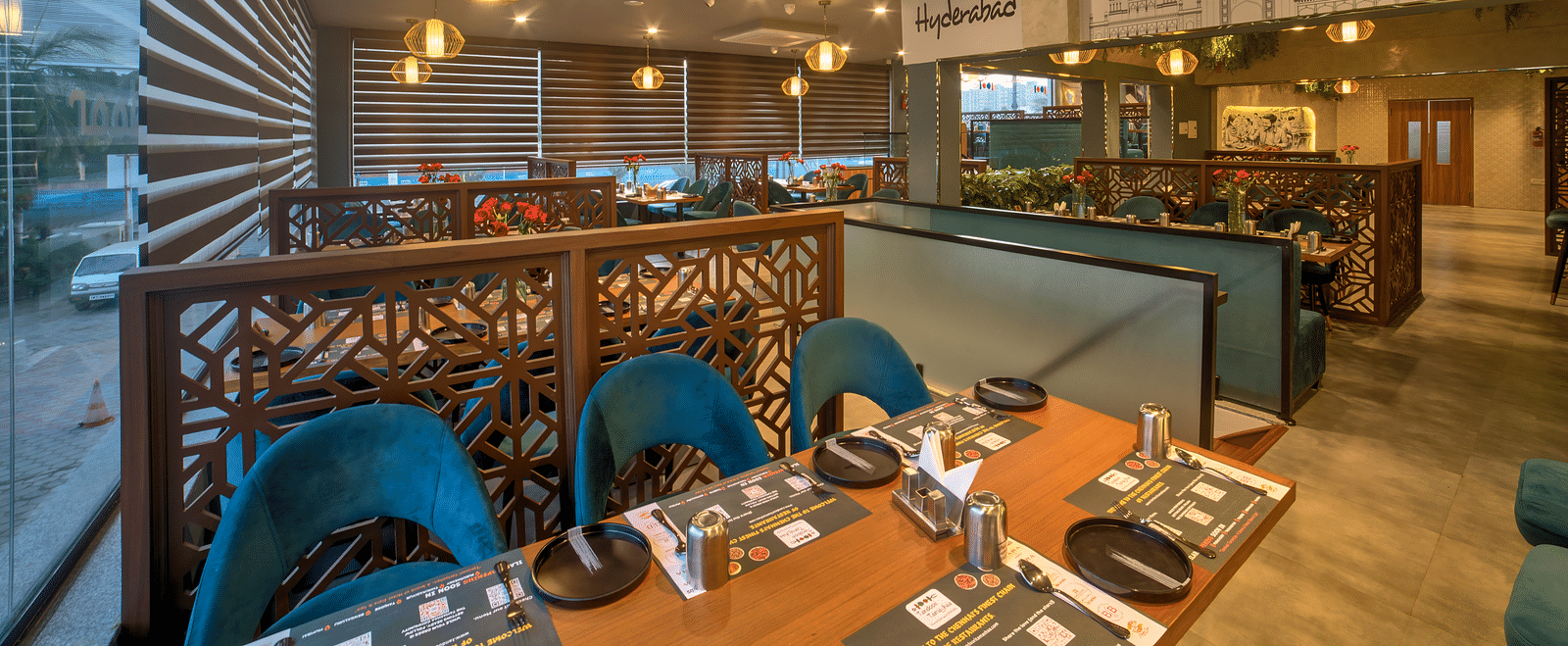 Wide-angle view of the restaurant with blue chairs and warm lighting at Ilara Hotels & Spa, OMR, Chennai