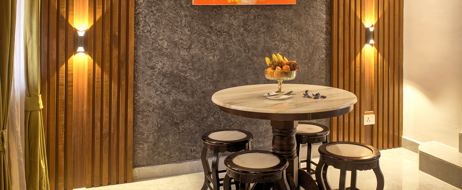 Compact dining nook with vibrant artwork and modern lighting at Ilara Hotels & Spa, OMR, Chennai