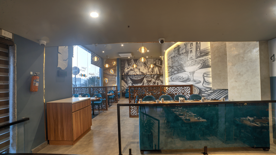 Artistic dining booths with blue seating and warm lighting at Ilara Hotels & Spa, OMR, Chennai