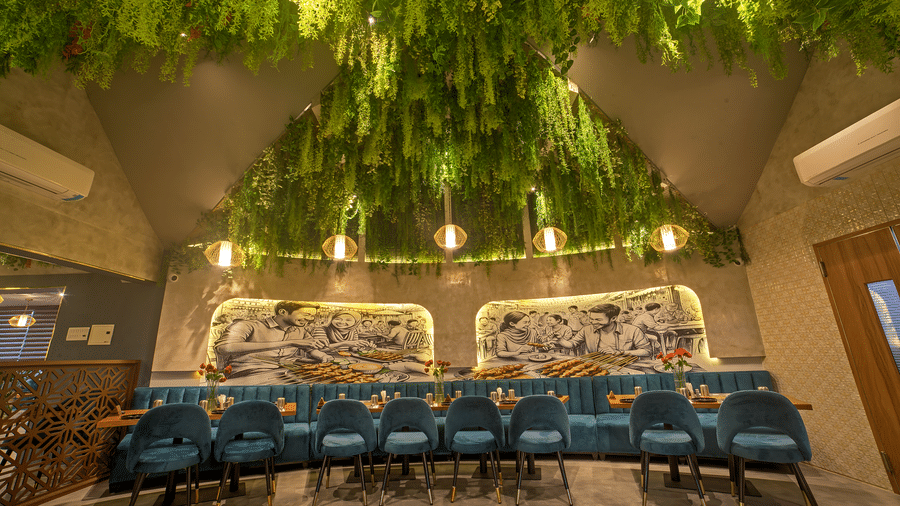 Stylish ceiling with hanging greenery above long dining table at Ilara Hotels & Spa, OMR, Chennai
