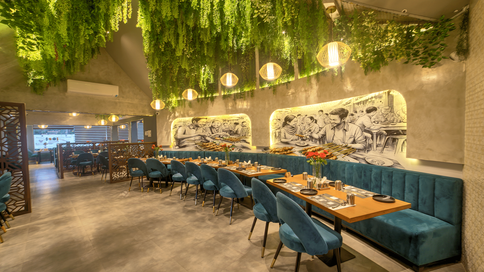 Long dining table under a lush green ceiling canopy at Ilara Hotels & Spa, OMR, Chennai