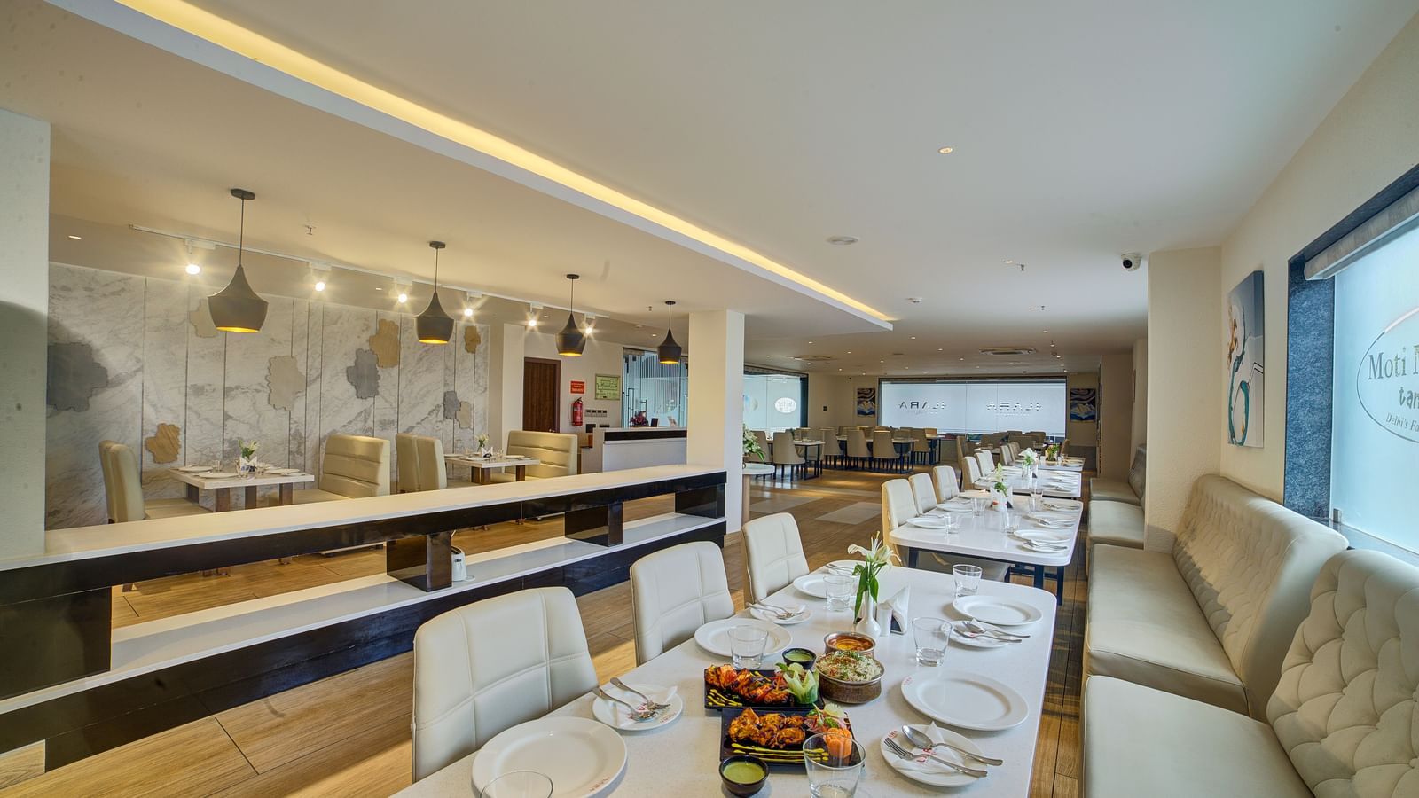  A modern, brightly-lit bar and lounge area with high stools, a sleek counter, and ambient lighting at Ilara Hotels & Spa.