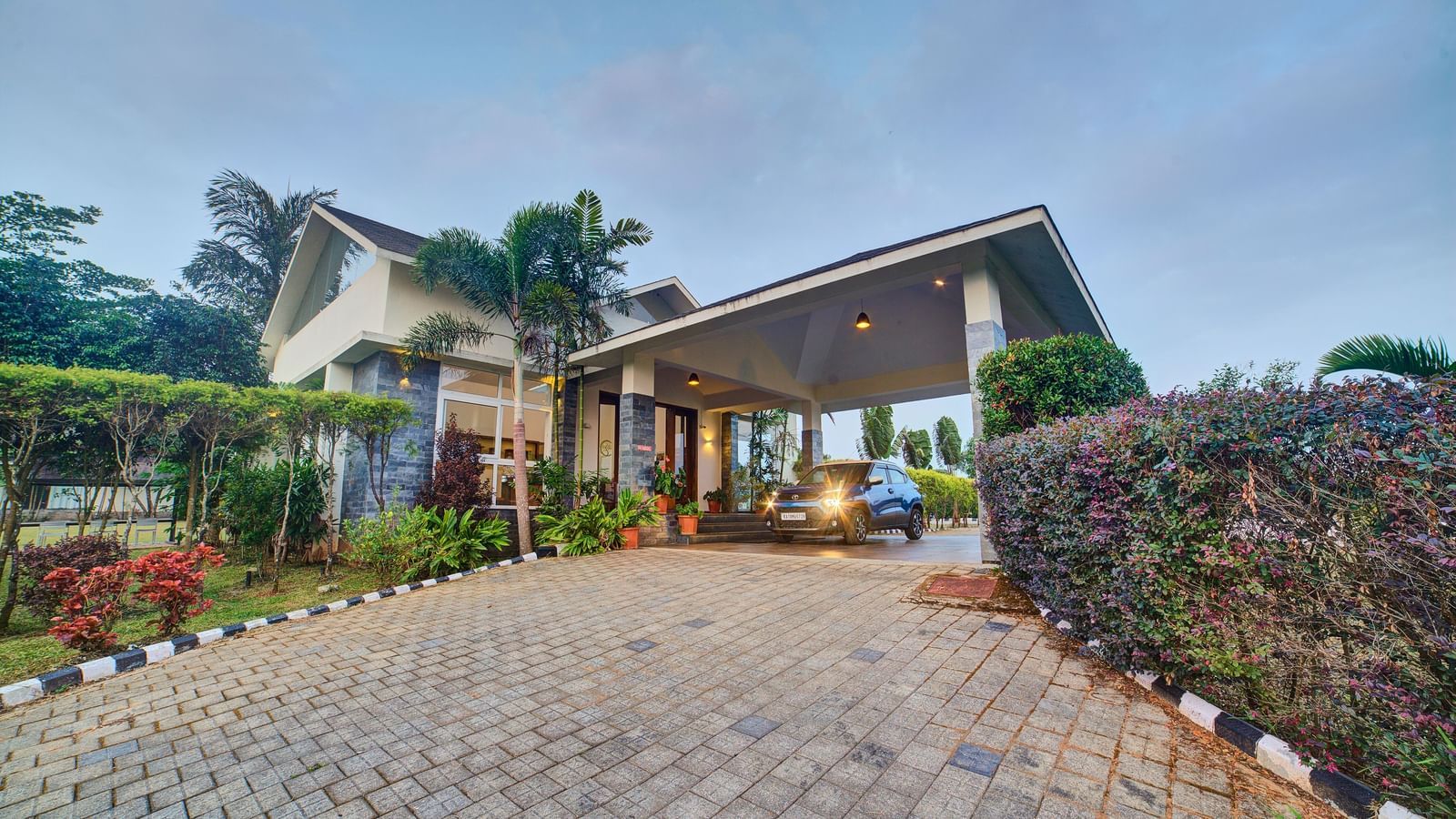 Exterior of a welcoming villa or hotel entrance surrounded by greenery and paved pathways under a clear sky at Ilara Hotels & Spa.