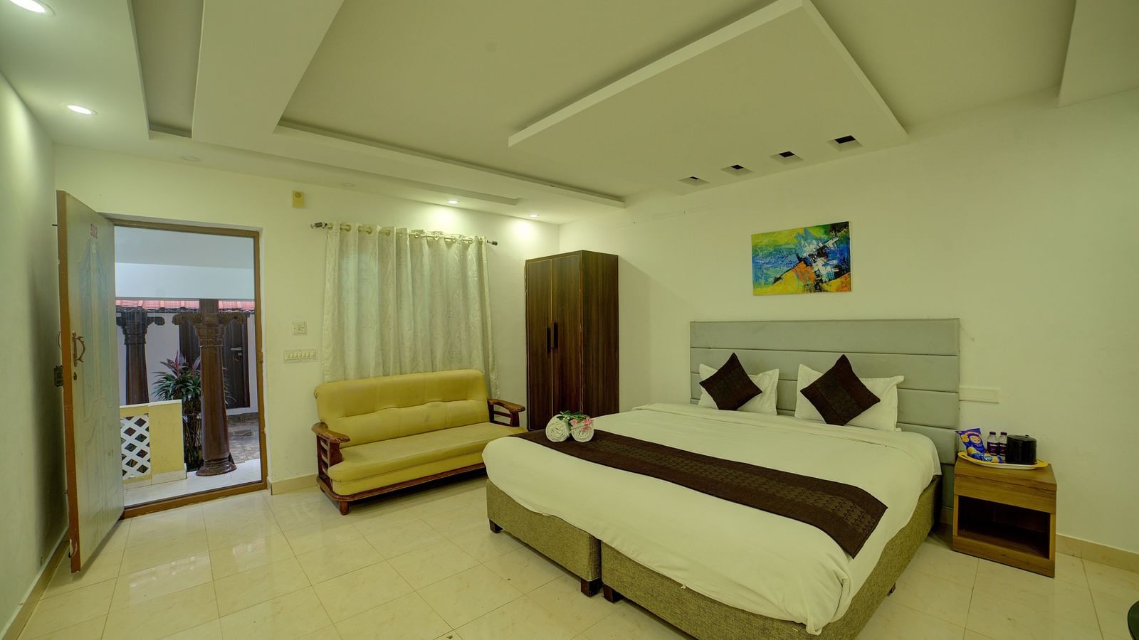 Contemporary bedroom with modern ceiling design and minimalistic interiors at Kailash Conventions ECR.