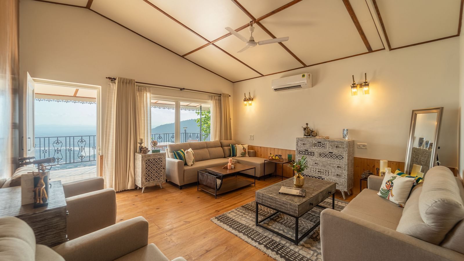 an overview of a living room with sofas and coffee tables inside one of the rooms - neer ganga Resorts