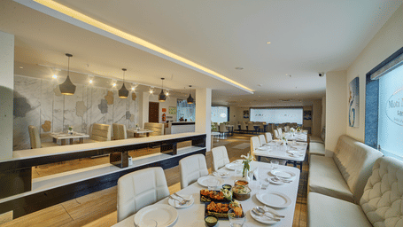 The interiors of a brightly lit dining area with beautifully served dishes on the table at Ilara Hotels & Spa, Tada.