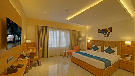 Full-view shot of the Signature Suite with a back lit false ceiling above the above the double bed at Ilara Hotels & Spa, Tada.