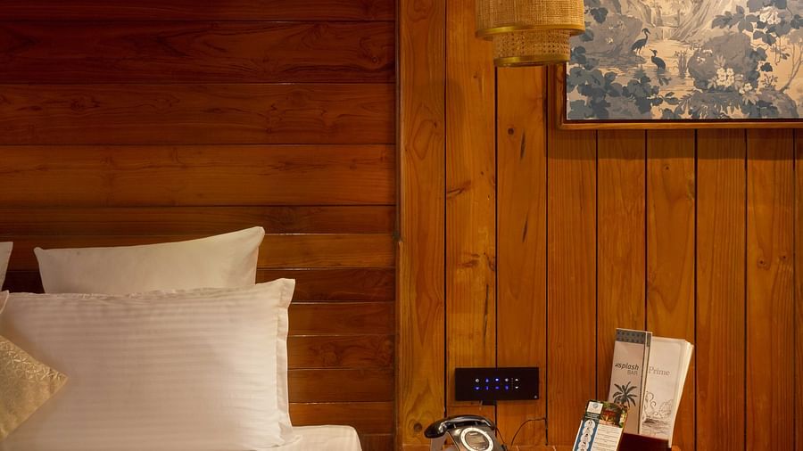 Image of pillows arranged on a bed next to which a nightstand is placed in  Coral Turquoise at Coral Reef Resort and Spa in Havelock