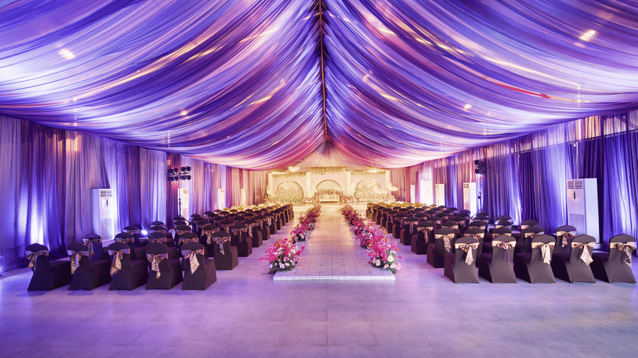 Indoor wedding hall with flowing purple draped ceiling and neatly arranged theatre style seating - Grande Bay Resort & Spa, Mamallapuram