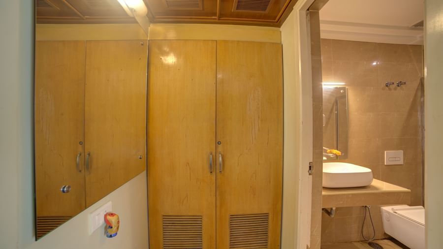 Wood-panelled wardrobe with adjacent sink and vanity area at Ilara Hotels & Spa, OMR, Chennai