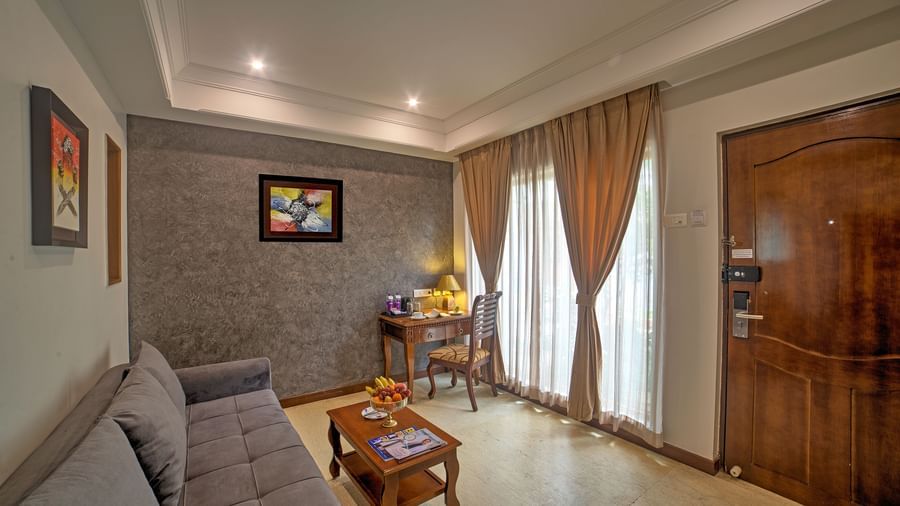 Contemporary suite with wooden door, sitting space, and soft lighting at Ilara Hotels & Spa, OMR, Chennai