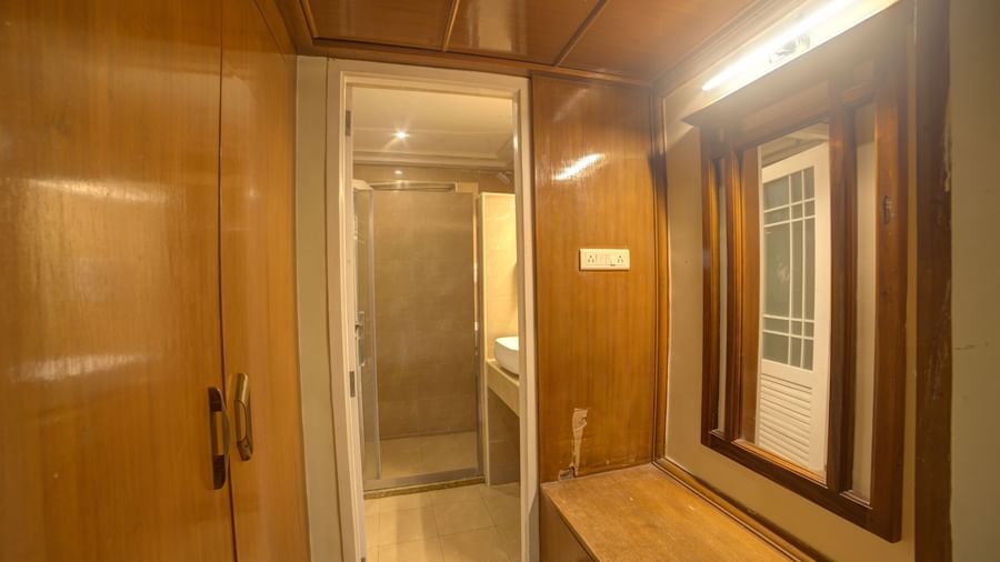 Changing area with wooden panelled wardrobe and enclosed glass door at Ilara Hotels & Spa, OMR, Chennai