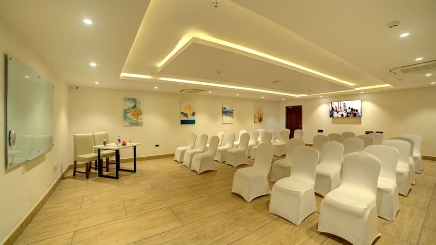 A banquet hall with chairs arranged in three in a row facing towards the projector at Ilara Hotels & Spa, Tada.