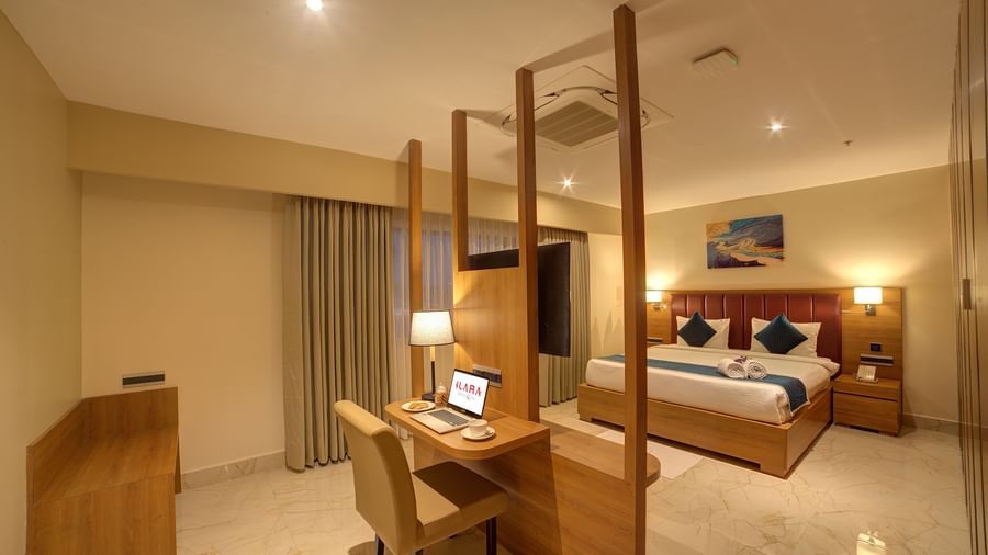 The bedroom of the Executive Suite with warm lighting along with a double bed and a work desk and chair in front of it at Ilara Hotels & Spa, Tada.