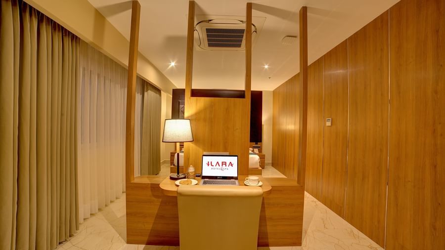 Front view shot of the work station with a cushioned chair and a laptop in front of it in the Executive Suite at Ilara Hotels & Spa, Tada.
