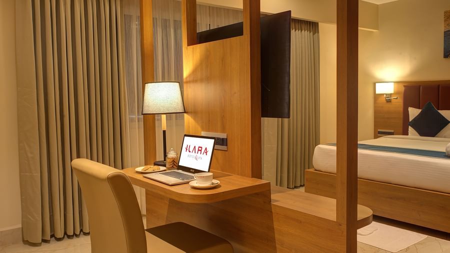 Corner view close up shot of the work station in the bedroom of the Executive Suite with a laptop and a table lamp kept on the desk at Ilara Hotels & Spa, Tada.