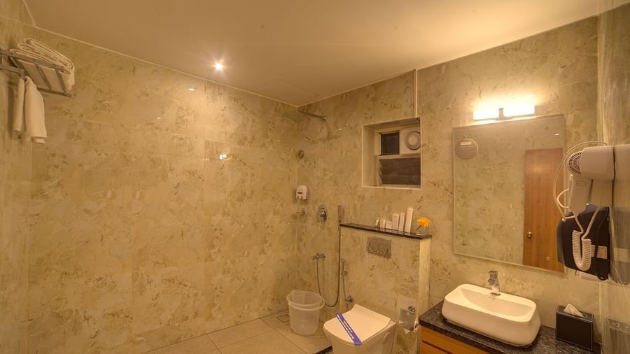 A bathroom with a wash basin and a vanity area in the corner at Ilara Hotels & Spa, Tada.