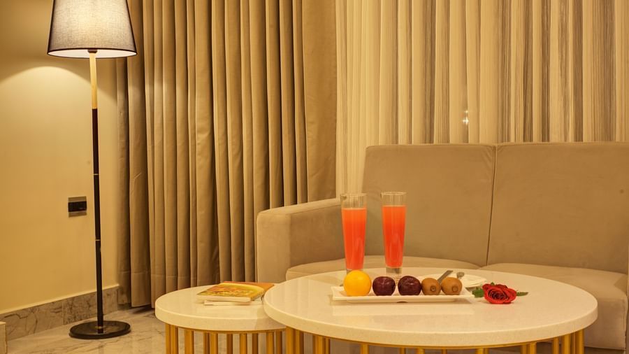 Close up shot of the coffee table with two tall glasses of fresh watermelon juice along with side dishes in the Junior Suite at Ilara Hotels & Spa, Tada.