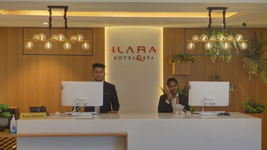 Close up shot of the reception desk at Ilara Hotels & Spa, Tada with two staff members dressed in business formals standing behind the desk.