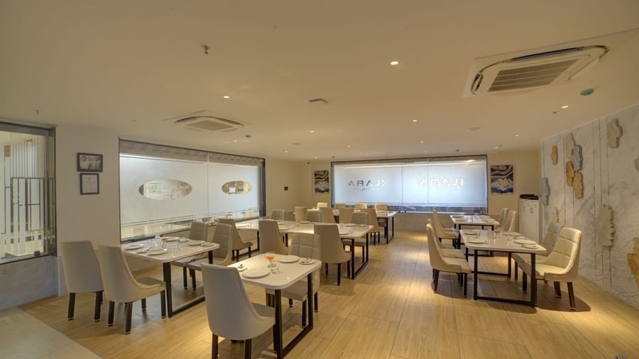 Full view shot of the Moti Mahal restaurant at Ilara Hotels & Spa, Tada with well arranged chairs and dining tables. 