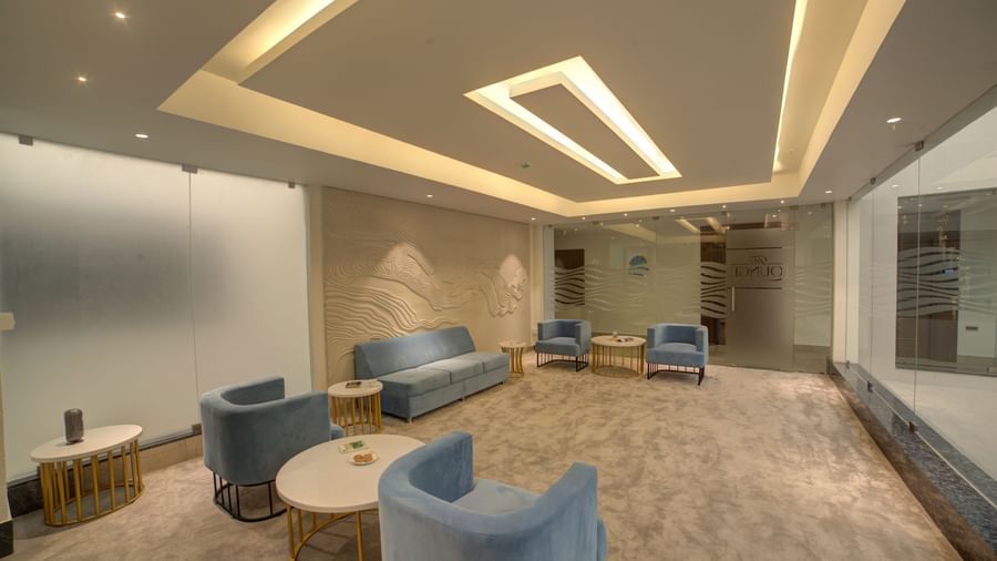 A wide angle shot of the lounge with plush couches kept at some distance at Ilara Hotels & Spa, Tada.