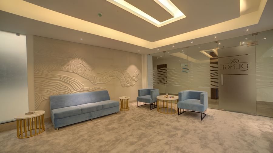 A wide angle shot of the lounge at Ilara Hotels & Spa, Tada with warm lighting coming from the false ceiling.