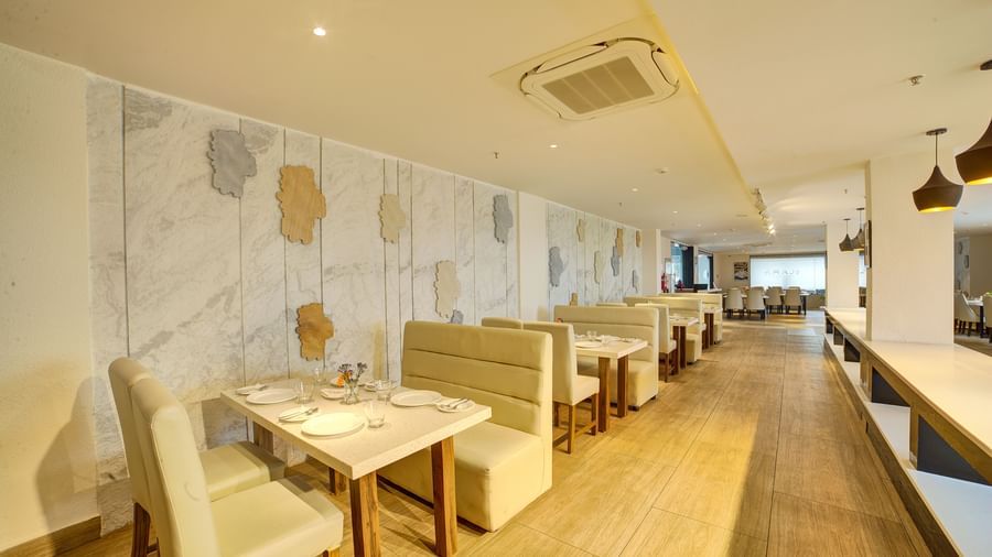 A wide angle shot of the dining area at Ilara Hotels & Spa, Tada with cushioned couches around the dining tables at Moti Mahal.
