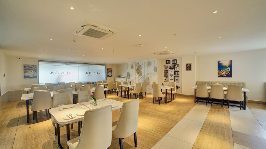 Back view of the Moti Mahal Restaurant with neatly arranged chairs and dining tables at Ilara Hotels & Spa, Tada.