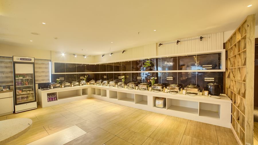 A wide angle shot of the Moti Mahal restaurant featuring a buffet counter in at the far end at Ilara Hotels & Spa, Tada.