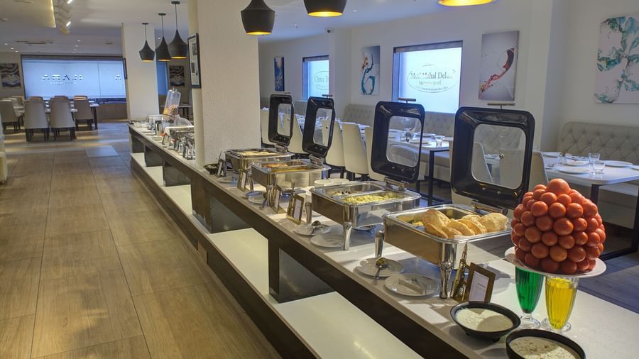 A close up shot of buffet counter with chafing dishes and serving spoons in front of it at Ilara Hotels & Spa, Tada.