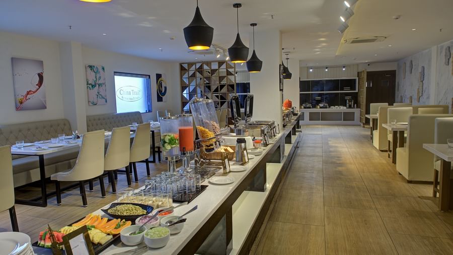 Full view shot of the buffet counter at the Moti Mahal Restaurant at Ilara Hotels & Spa, Tada with ambient lighting hanging from the ceiling above it.