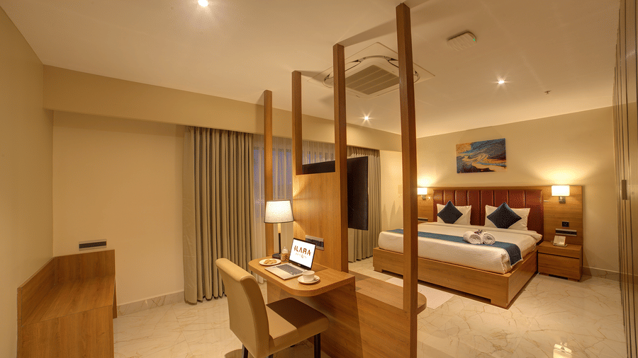 The bedroom of the Executive Suite with warm lighting along with a double bed and a work desk and chair in front of it at Ilara Hotels & Spa, Tada.