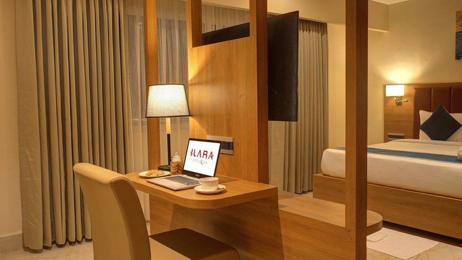 Corner view close-up shot of the work station in the bedroom of the Executive Suite with a laptop and a table lamp kept on the desk at Ilara Hotels & Spa, Tada.