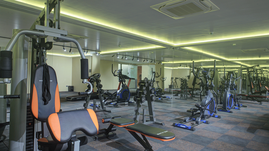 A wide view of the fitness centre with various gym equipment and modern lighting at Ilara Hotels & Spa, Tada.
