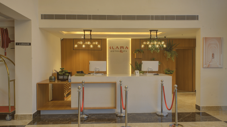 Front-view shot of the front desk with 2 desktops on the table at Ilara Hotels & Spa, Tada.