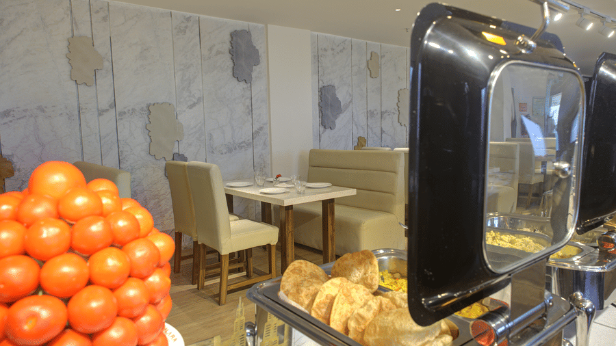 A close-up shot of a buffet with chafing dishes overlooking the dining tables at Moti Mahal restaurant at Ilara Hotels & Spa, Tada.