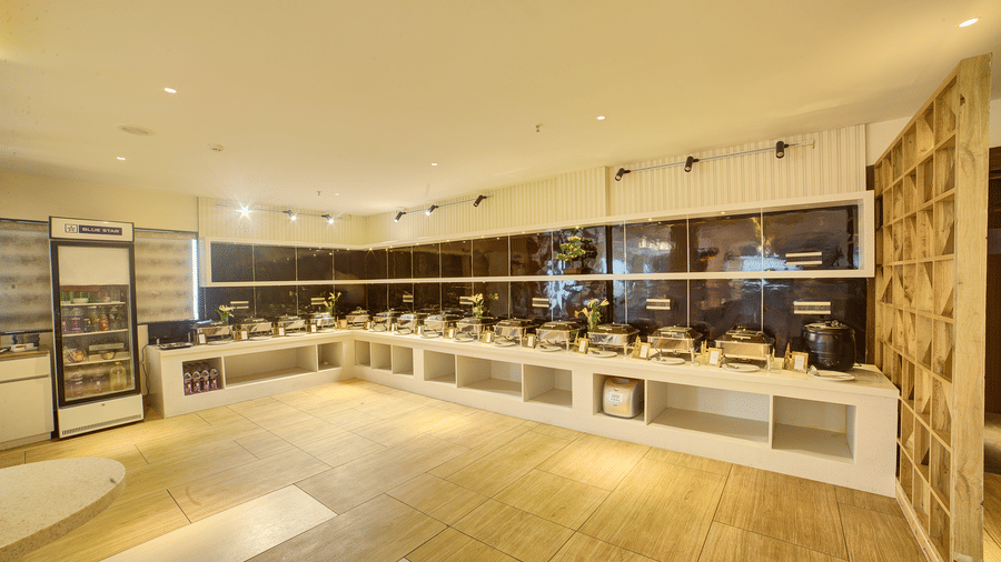 A wide-angle shot of the Moti Mahal restaurant featuring a buffet counter in at the far end at Ilara Hotels & Spa, Tada.