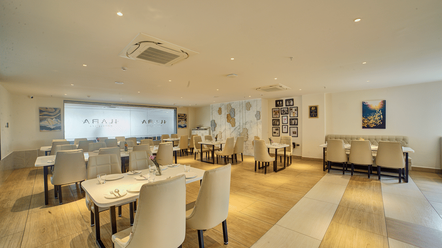 Back view of the Moti Mahal Restaurant with neatly arranged chairs and dining tables at Ilara Hotels & Spa, Tada.