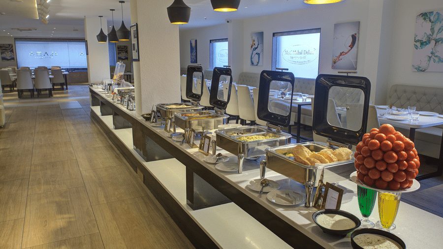 A close-up shot of buffet counter with chafing dishes and serving spoons in front of it at Ilara Hotels & Spa, Tada.